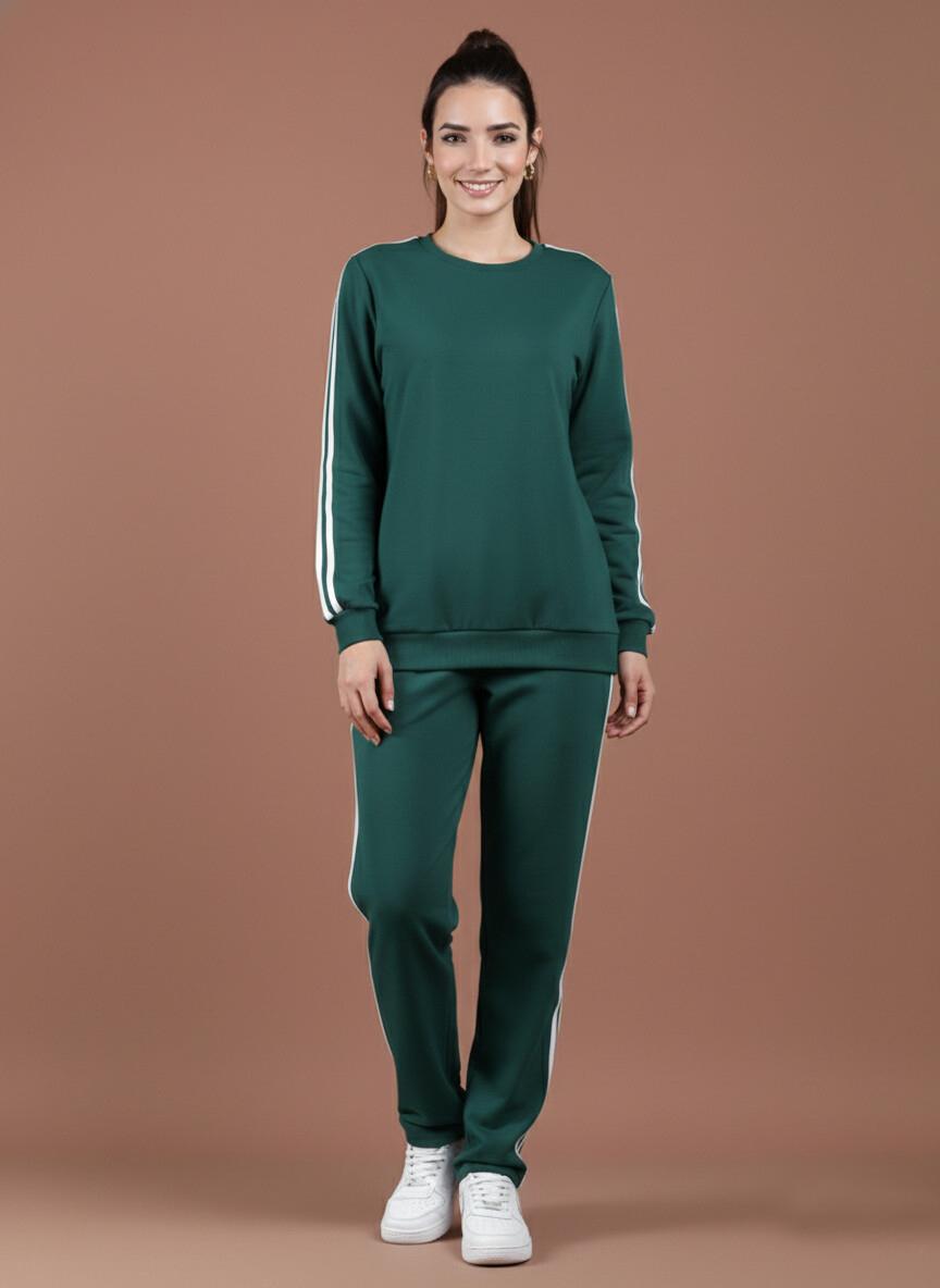 Woman wearing a green tracksuit or co-ords with white stripes on a brown background