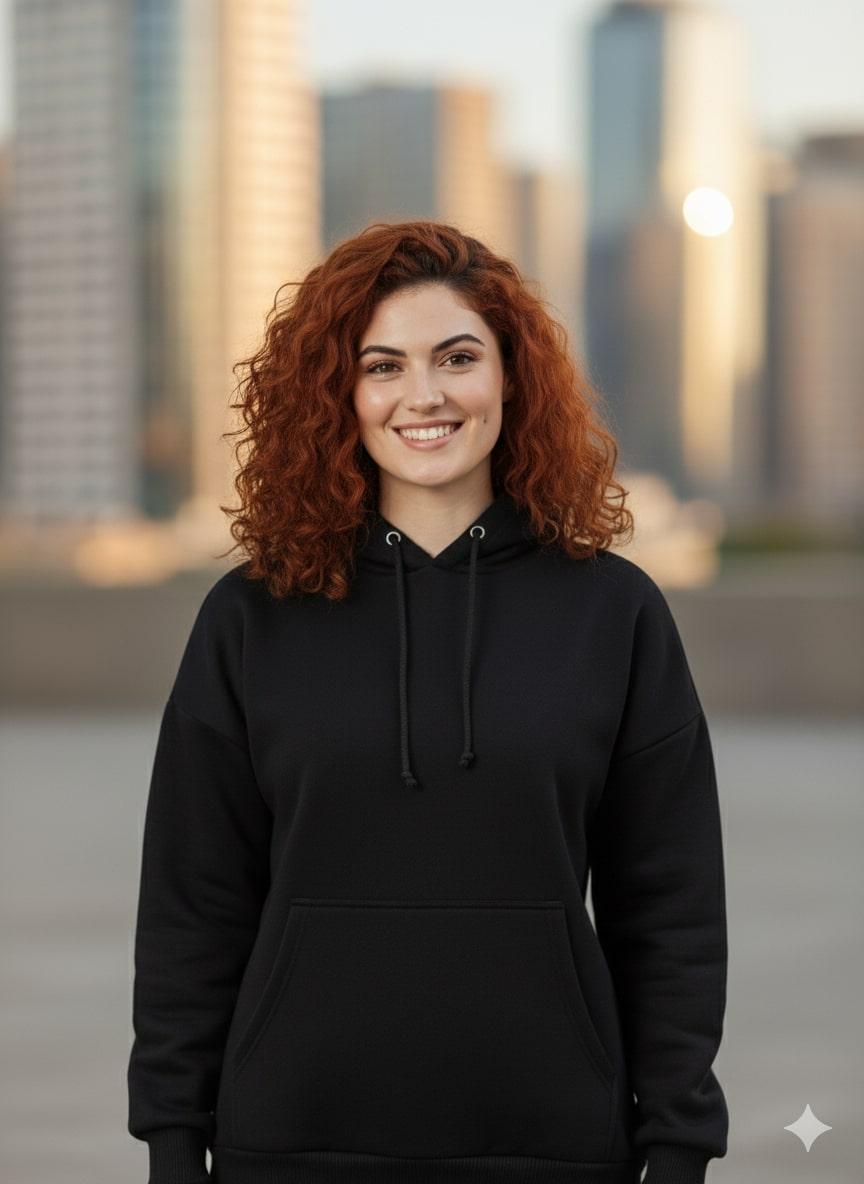 Person wearing a black hoodie with a blurred cityscape background