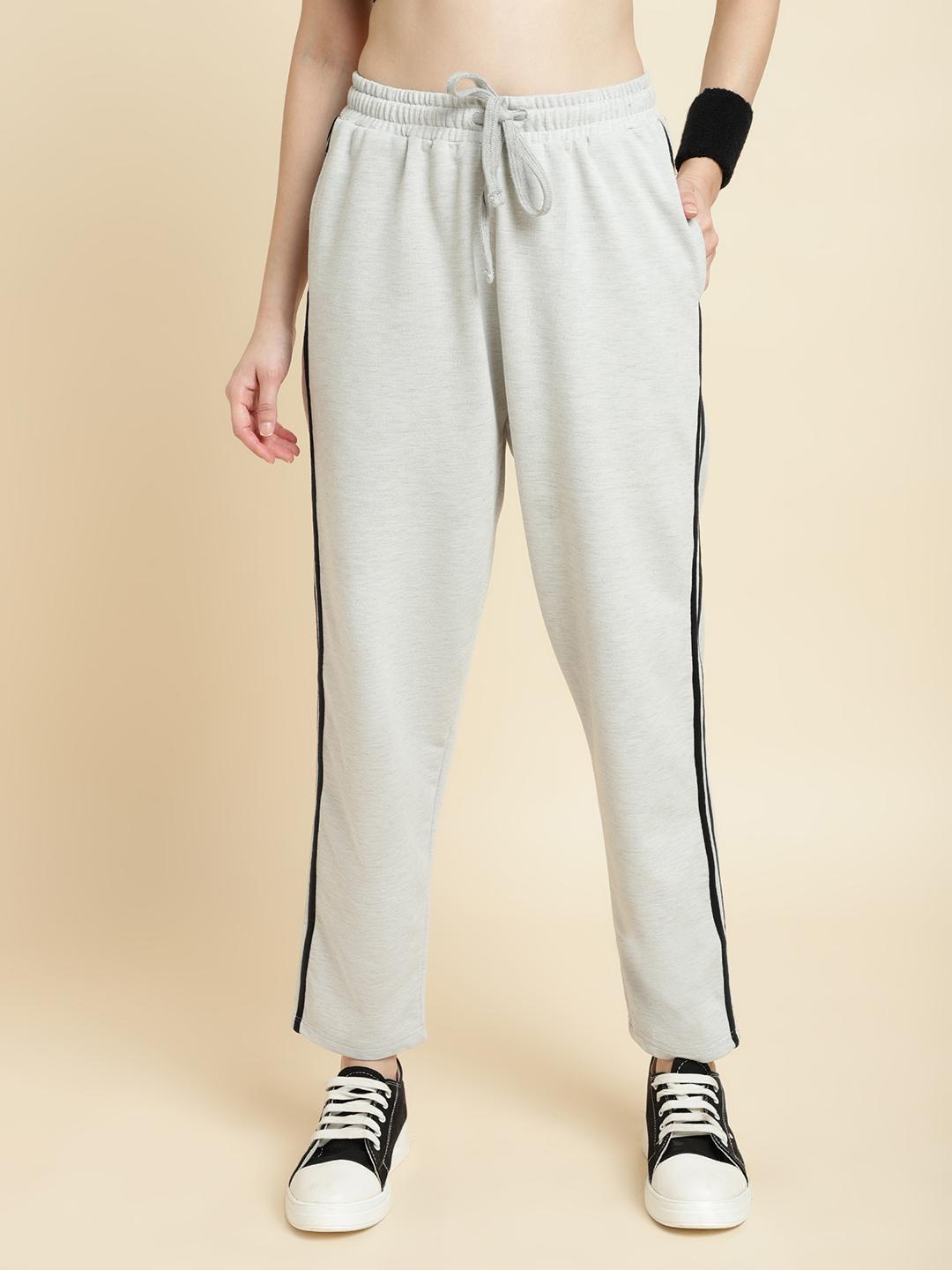 Light gray sweatpants with black stripes worn by a person on a beige background