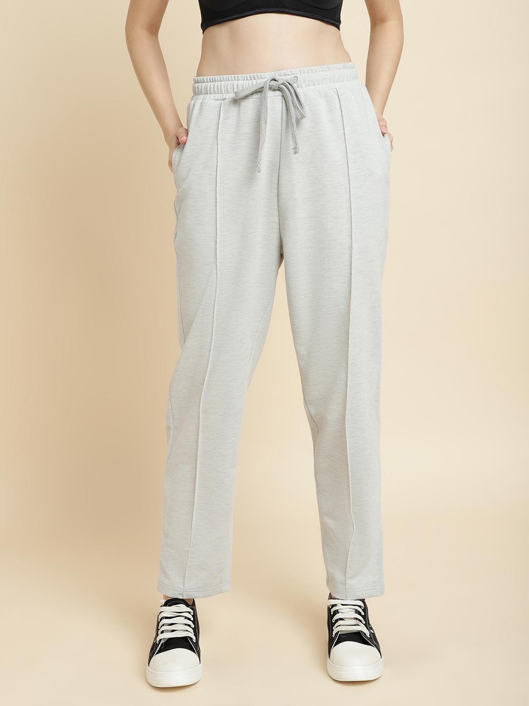 Light gray jogger pants worn by a person on a beige background