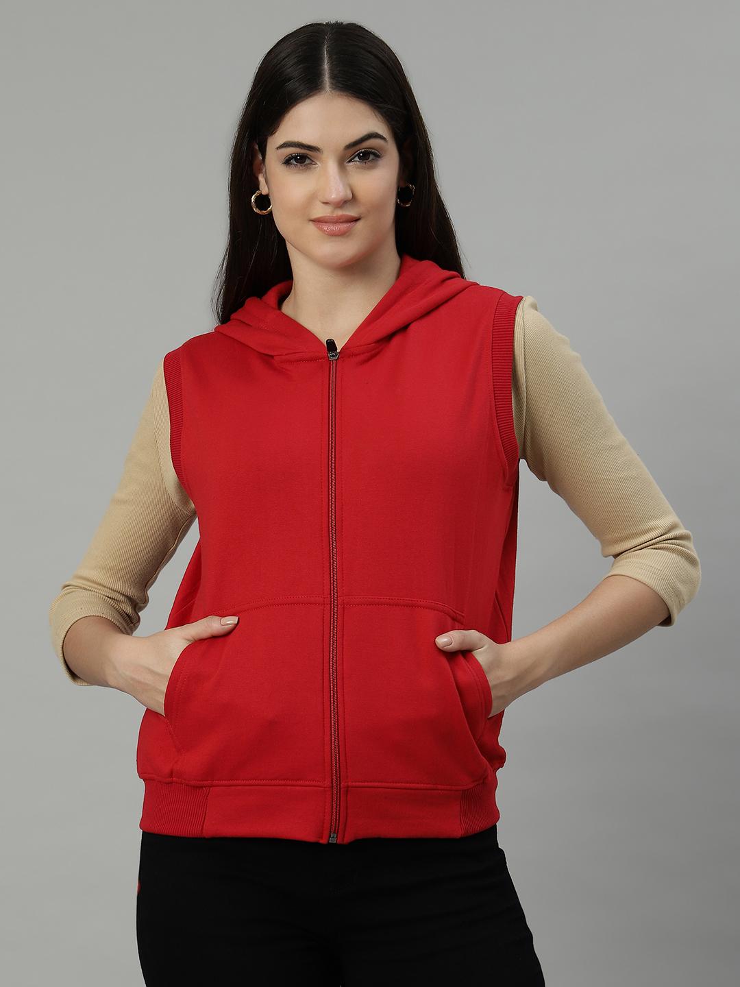 Woman wearing a red hooded sweatshirt over a beige long-sleeve shirt on a gray background