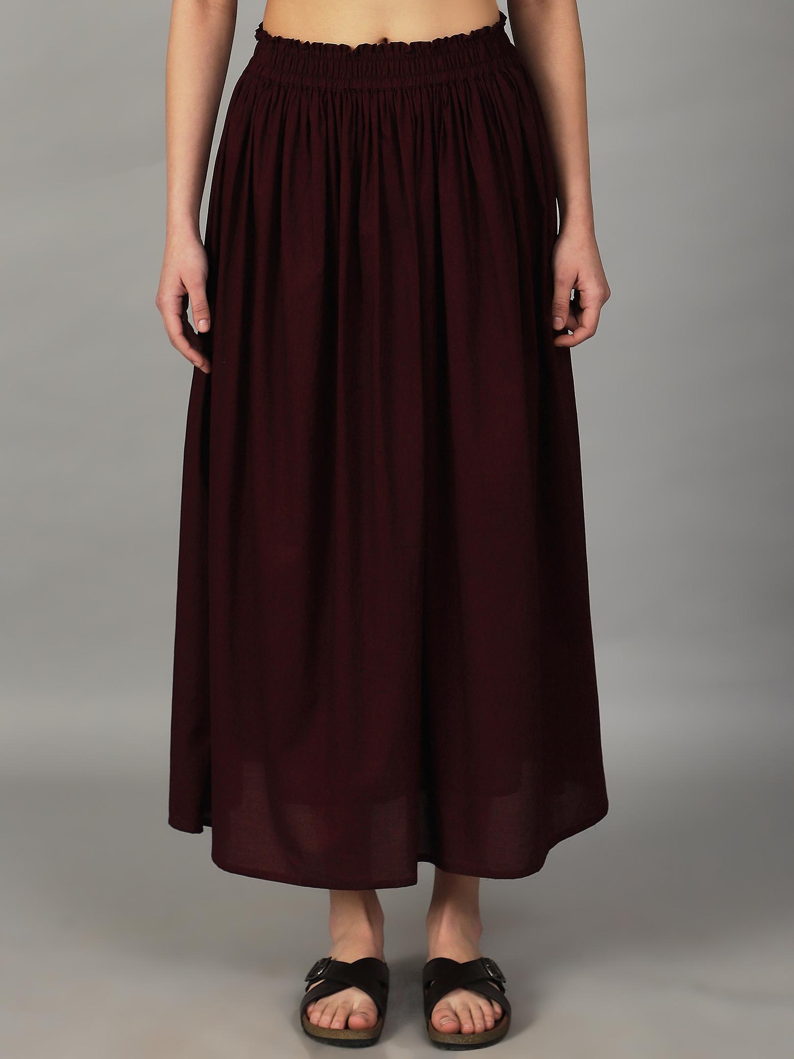 Maroon skirt worn by a girl on a gray background