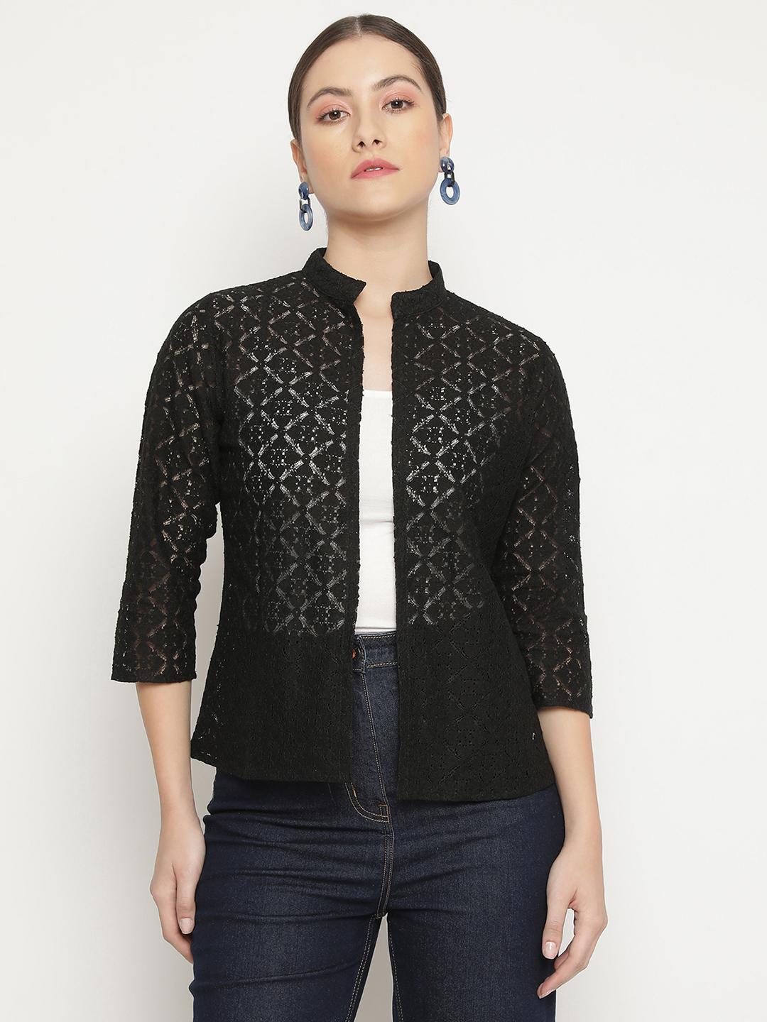 Woman wearing a black lace Shrug over a white top and dark jeans on a white background