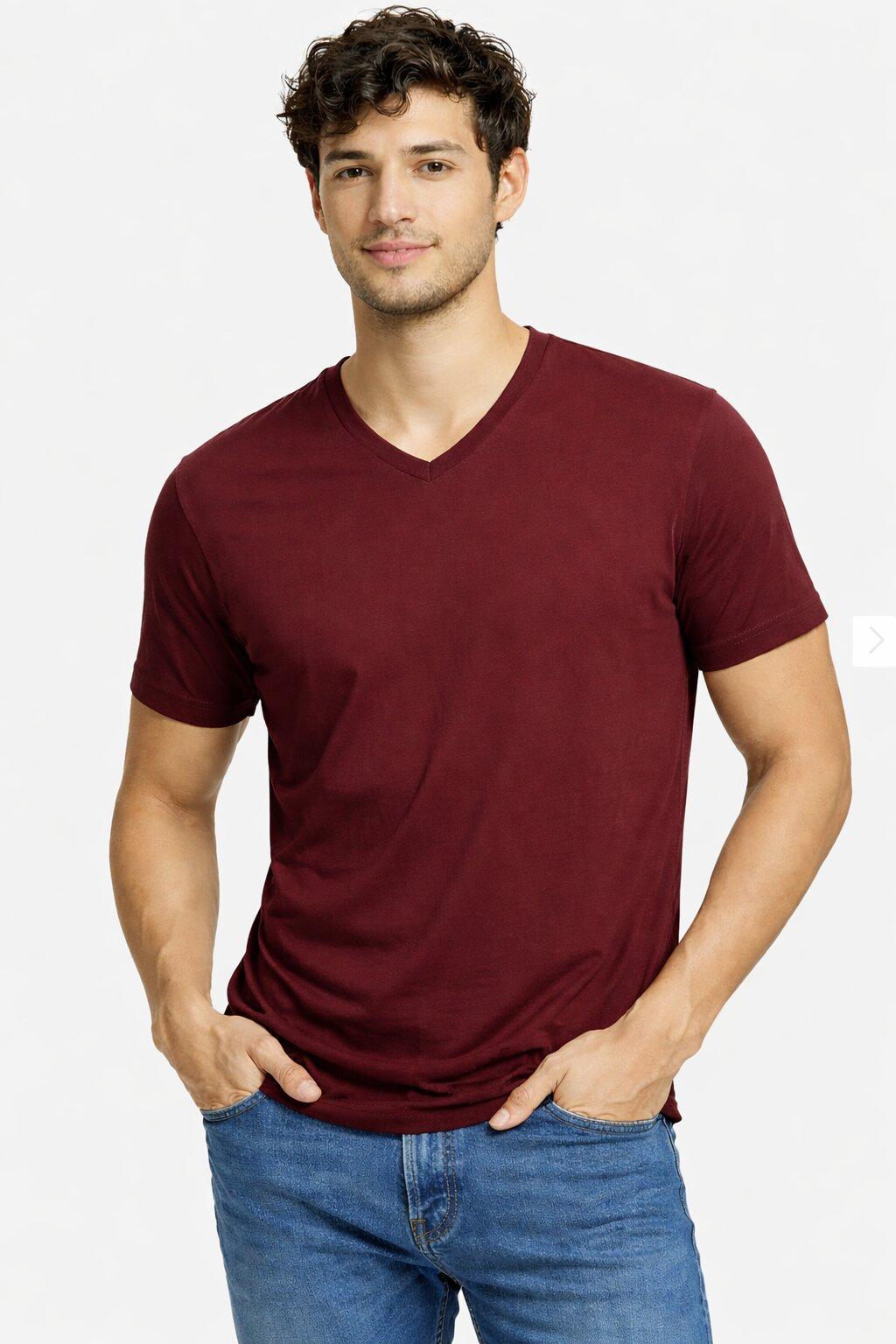 Man wearing a maroon t-shirt and blue jeans on a white background