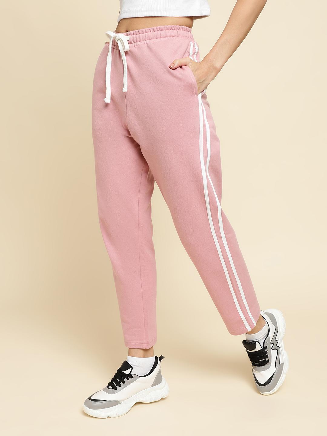 Pink track pants with white stripes on a beige background