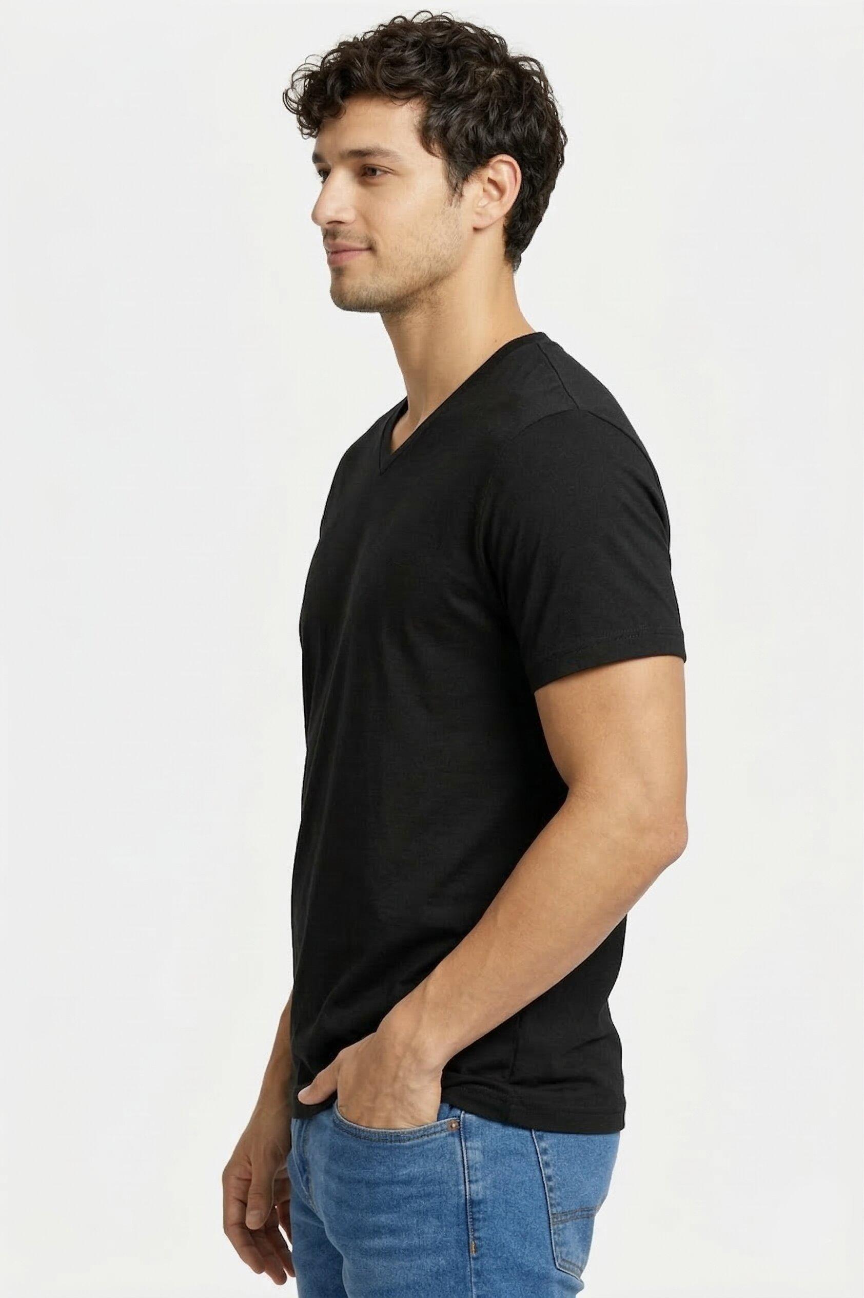 Man wearing a pure cotton black V-neck t-shirt and blue jeans on a white background