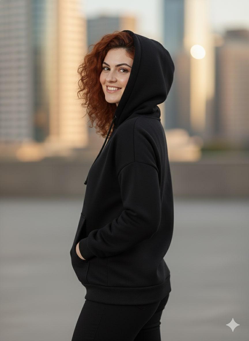 Person wearing a black sweatshirt with a blurred cityscape background