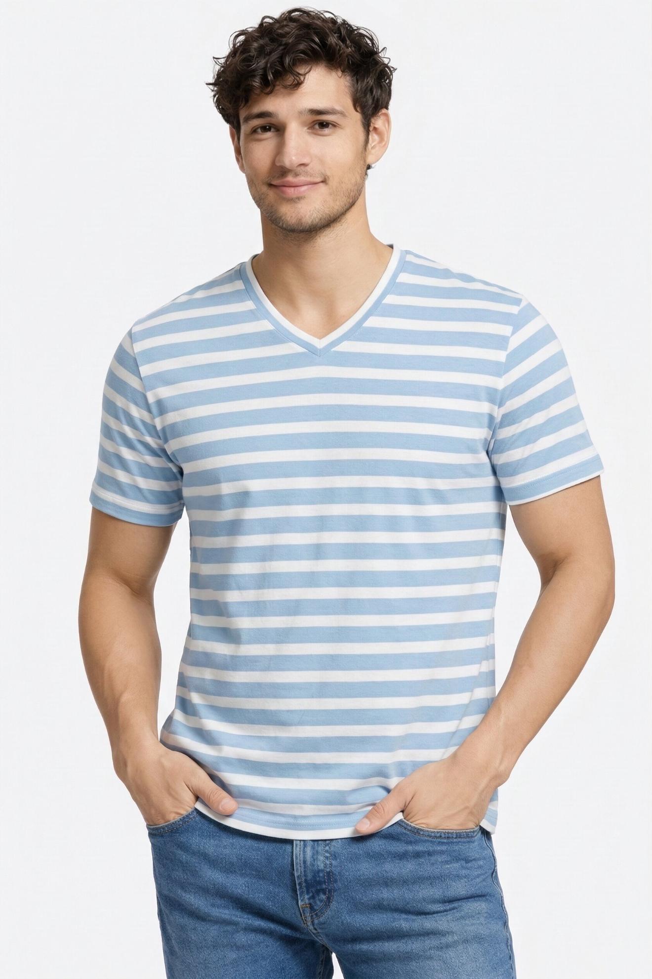 Man wearing a blue and white striped shirt with jeans on a light gray background