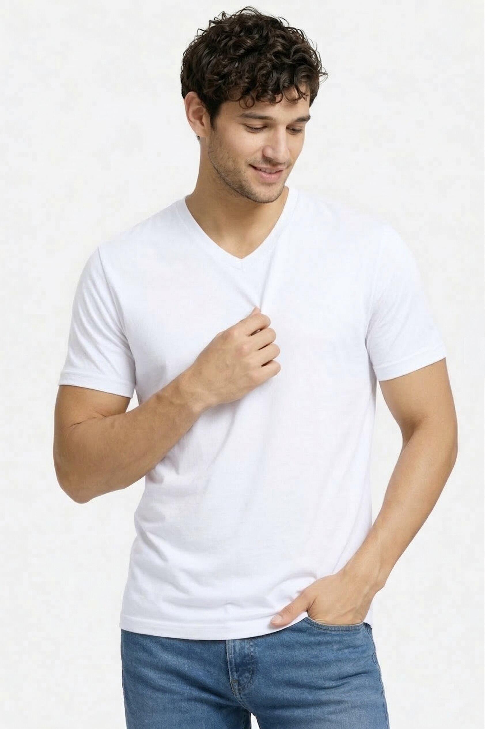 Man wearing a plain white t-shirt and blue jeans on a light gray background