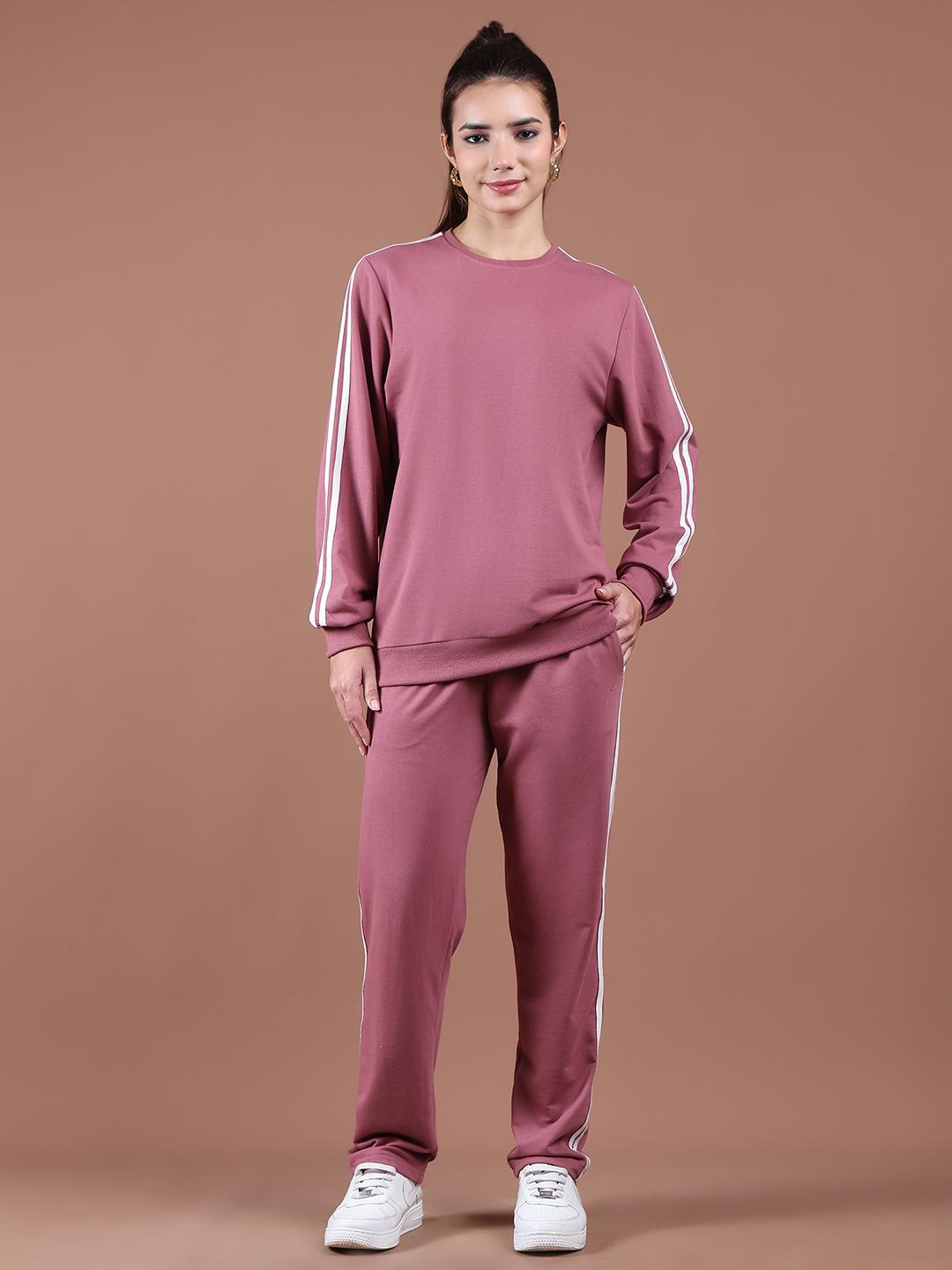 Woman wearing onion tracksuit with white stripes on a brown background